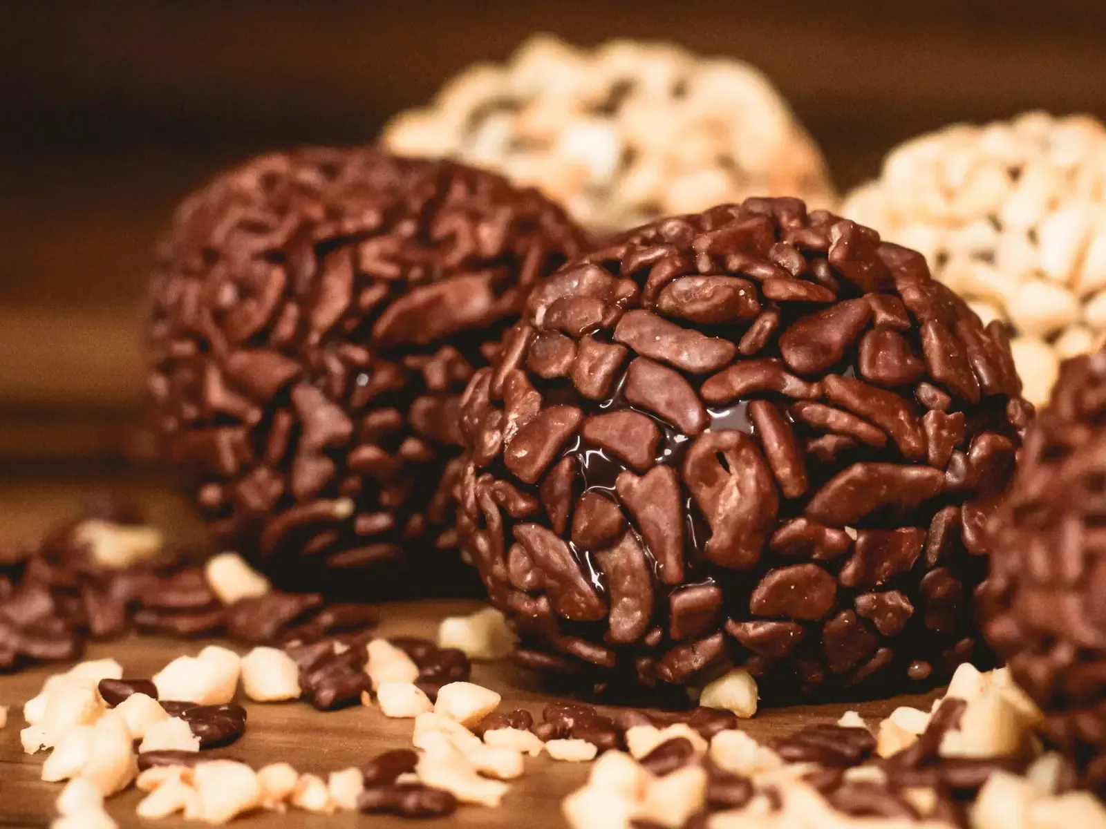 Nahaufnahme von Brigadeiros mit Schokoladenstreuseln und gehackten Nüssen